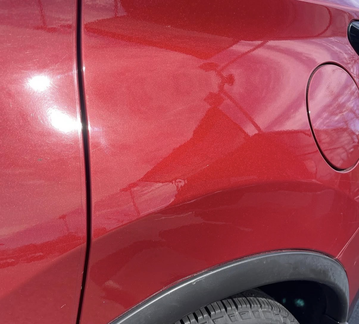 Red SUV rear quarter panel smooth and restored after paintless dent repair