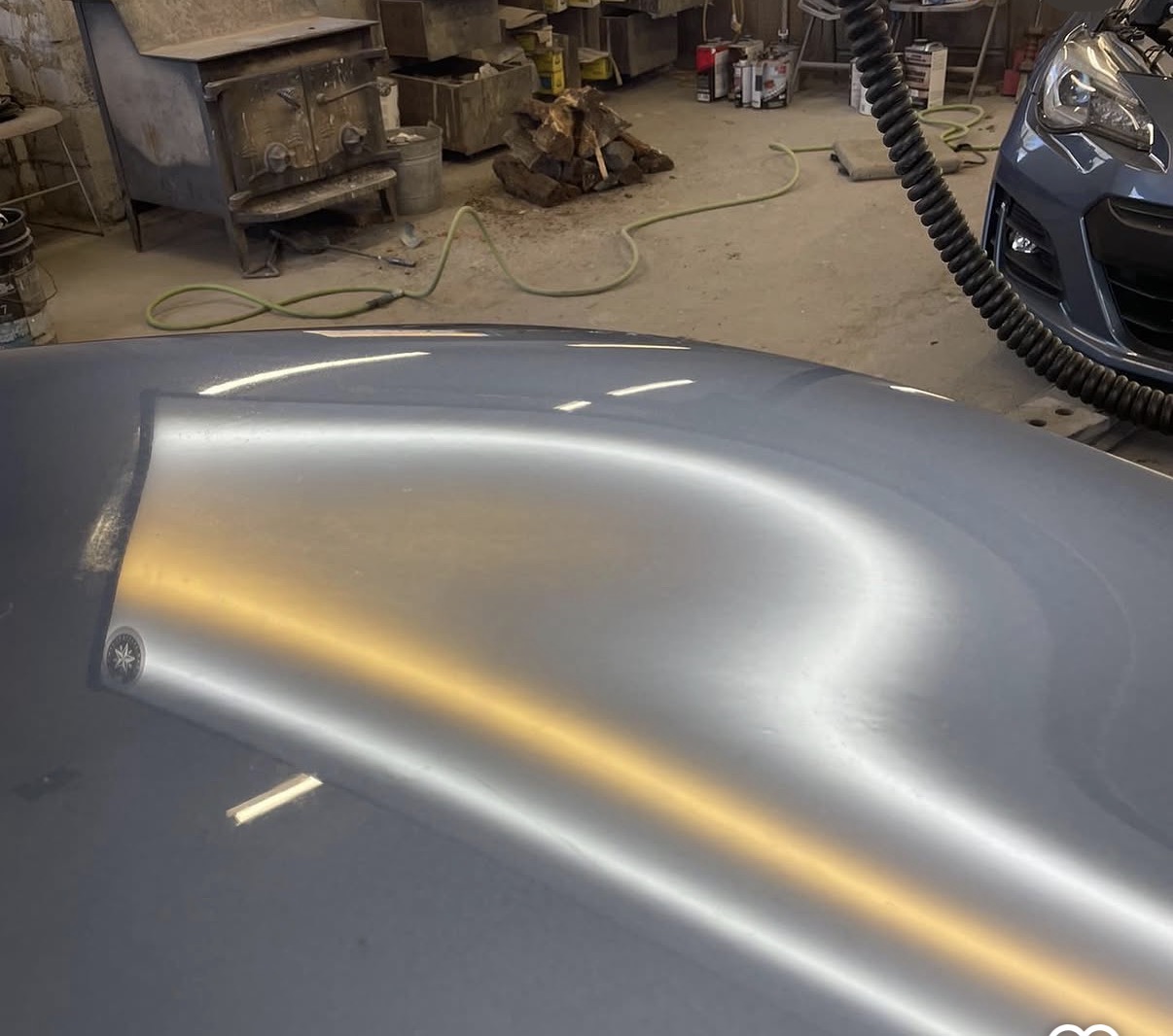 Vehicle panel with a smooth, clean reflection after paintless dent repair