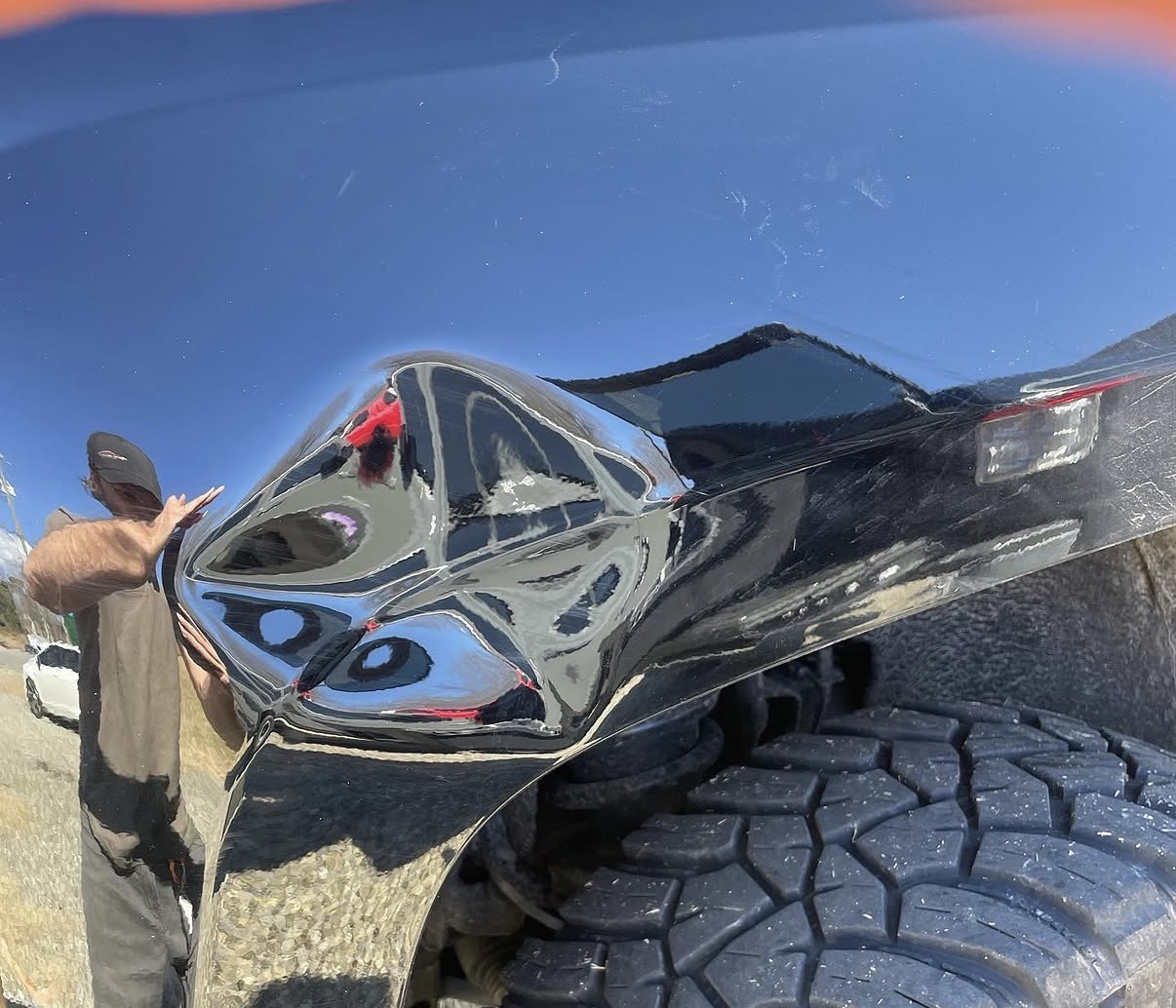 Black pickup truck bedside with a large dent before paintless dent repair